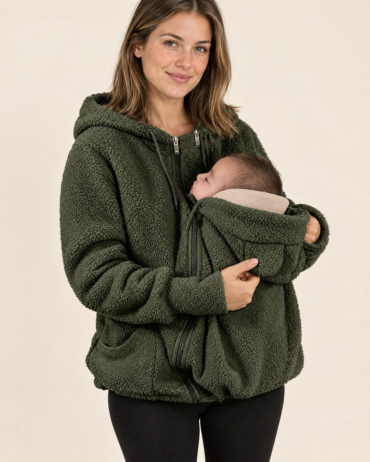 Mama trägt die Kuscheljacke in Olivgrün mit Baby im Babyeinsatz