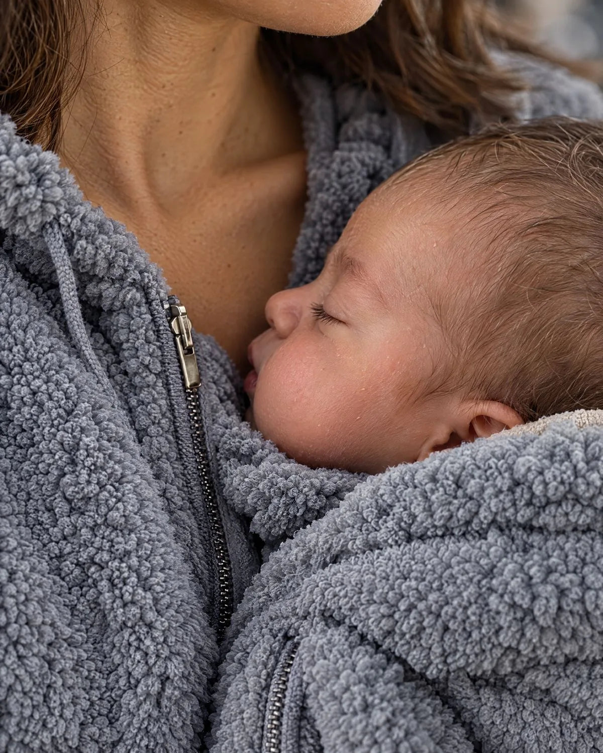 Babys Wange liegt an Mamas Brust, Nahaufnahme